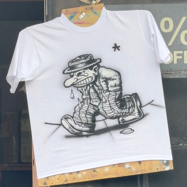 White short-sleeve tee featuring black cartoon artwork of a grinning character in a hat and striped trousers.